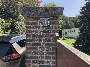 cloche installée au pilier du portail de la maison