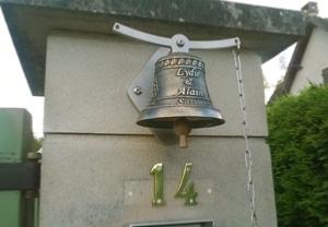 on acheteer une cloche en bronze installée au portail d'une maison