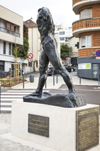 Fabrication de plaques en bronze personnalises scelles au pied d'une stle comportant une statue, oeuvre d'art